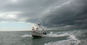 people on boat with storm coming in