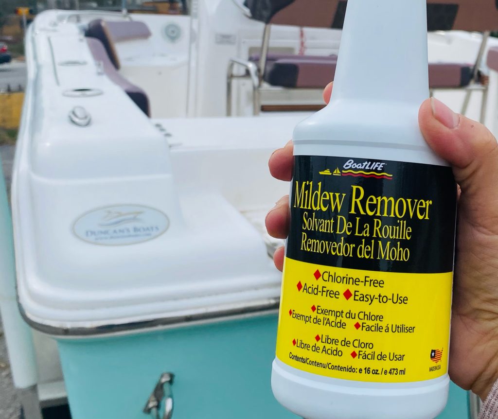Mildew remover being held in front of a boat.